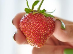 Hand holding a strawberry