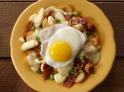 Breakfast poutine with bacon, sausage and sunny side up egg.
